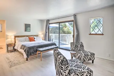 a bedroom with a bed and two chairs and a window at Boho-Chic Home with Game Room Near Lake Gregory! in Crestline