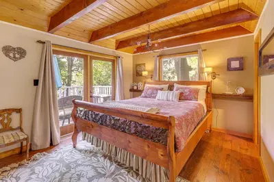 a bedroom with a large bed and a window at Game Room and 2 Decks Walkable Lake Arrowhead Cabin in Lake Arrowhead
