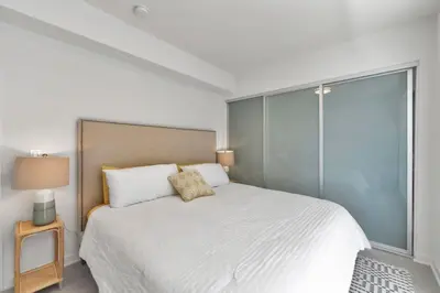 a white bedroom with a large bed and a window at 3 Lux large apartment heart of SM in Los Angeles