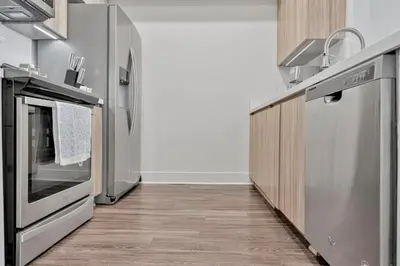 a kitchen with stainless steel appliances and wooden cabinets at 3 Lux large apartment heart of SM in Los Angeles