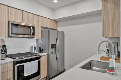a kitchen with a stainless steel refrigerator and a sink at 3 Lux large apartment heart of SM in Los Angeles
