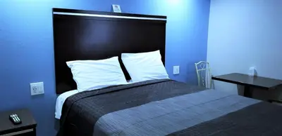 a blue bedroom with a bed with a black headboard at DAY N NIGHT INN - Near Universal Studios Hollywood in Los Angeles