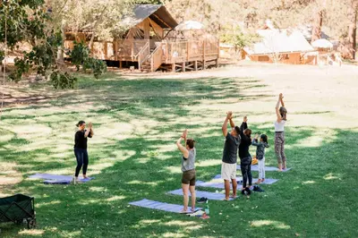 a group of people doing yoga in the grass at Huttopia Paradise Springs in Valyermo