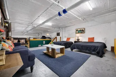 a room with two beds and a couch and a table at St. Vincent Lofts in Los Angeles