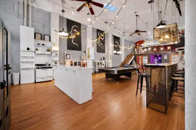 a kitchen with white cabinets and a bar in a room at St. Vincent Lofts in Los Angeles
