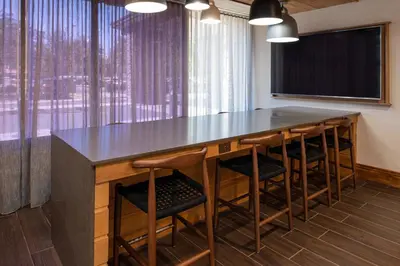 a conference room with a bar with chairs and a large window at Fairfield Inn and Suites by Marriott Bakersfield Central in Bakersfield