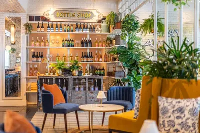 a restaurant with a bar with bottles on the wall at SIXTY Beverly Hills in Los Angeles