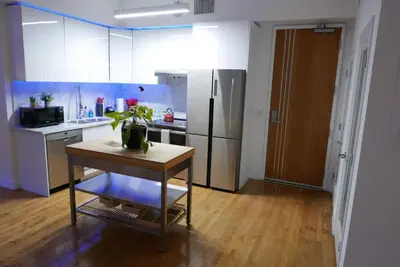 a kitchen with a table and a stainless steel refrigerator at One Lux Stay HWH Downtown Los Angeles in Los Angeles