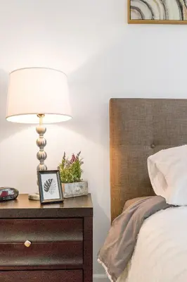 a lamp on a night stand next to a bed at One Lux Stay HWH Downtown Los Angeles in Los Angeles