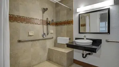 a bathroom with a sink and a mirror and a shower at Studio 6 Ontario CA Convention Center Airport in Ontario