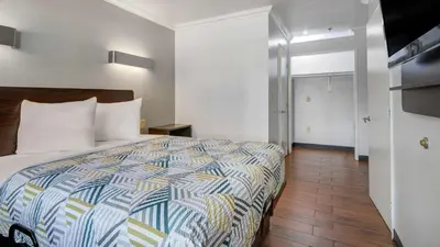 a hotel room with a bed and a bathroom at Studio 6 Ontario CA Convention Center Airport in Ontario