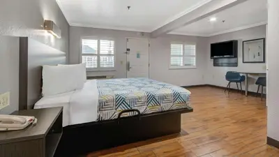a hotel room with a bed and a desk and a desk at Studio 6 Ontario CA Convention Center Airport in Ontario