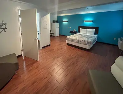 a bedroom with a bed and a blue wall at Studio 6 Ontario CA Convention Center Airport in Ontario