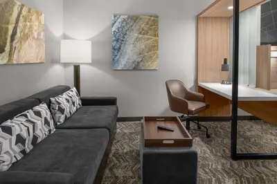 a living room with a couch and a table and a chair at SpringHill Suites by Marriott Riverside Redlands in Redlands