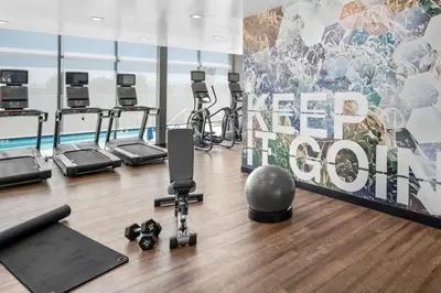 a gym with several treadmills and a sign that reads deadpool at SpringHill Suites by Marriott Riverside Redlands in Redlands