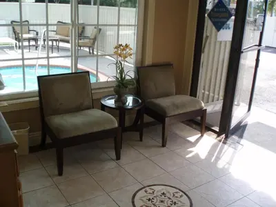 two chairs and a table in front of a pool at Abby's Anaheimer Inn - Across Disneyland Park in Anaheim