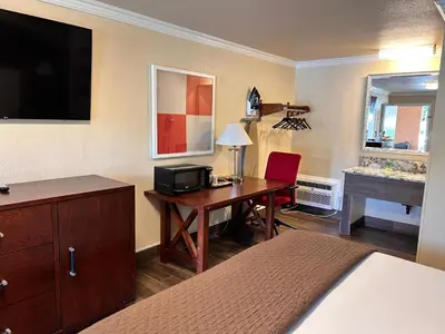 a hotel room with a desk and a bed at Abby's Anaheimer Inn - Across Disneyland Park in Anaheim