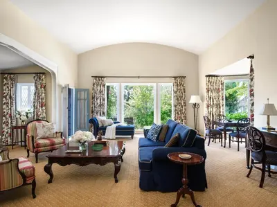 a living room with a blue couch and chairs at The Langham Huntington, Pasadena in Pasadena