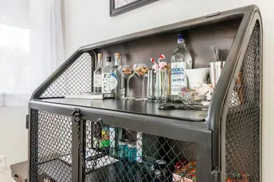 a metal bar cart with alcohol bottles on it at Sunny Boho Chic West Hollywood Flat! in Los Angeles
