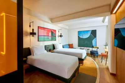 a hotel room with two beds and a desk at HOLLYWOOD VOLUME, a Tribute Portfolio Hotel in Los Angeles