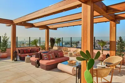 a patio with couches and chairs and a wooden pergola at HOLLYWOOD VOLUME, a Tribute Portfolio Hotel in Los Angeles