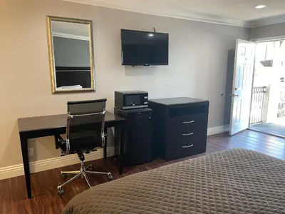 a bedroom with a desk and a bed with a computer at Legacy inn & suites in Anaheim