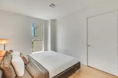 a white bedroom with a bed and a window at Apart Hotel near Dodgers Stadium in Los Angeles