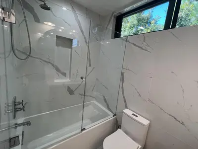 a white bathroom with a shower and a toilet at Modern Bright New Studio with Roof-top Deck Walk to Santa Monica Beach, FreeWiFi, Parking in Santa Monica