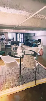 a living room with a table and a couch at Huge Downtown LA Loft with Rooftop Pool & Jacuzzi in Los Angeles