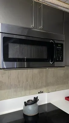 a microwave oven above a stove with a pot at Huge Downtown LA Loft with Rooftop Pool & Jacuzzi in Los Angeles