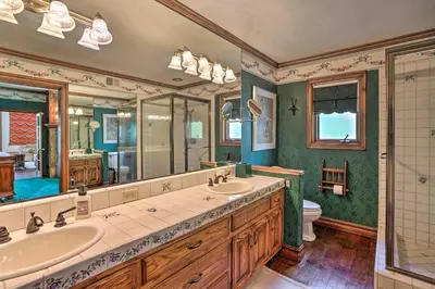 a bathroom with two sinks and a large mirror at Ornate Lake Arrowhead Home with Deck in Lake Arrowhead