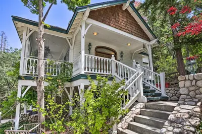 a white house with a staircase leading up to it at Ornate Lake Arrowhead Home with Deck in Lake Arrowhead