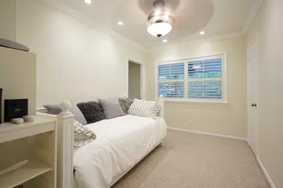 a bedroom with a white bed and a window at Bakersfield Oasis Sweet Tropical Pool Setup! in Bakersfield