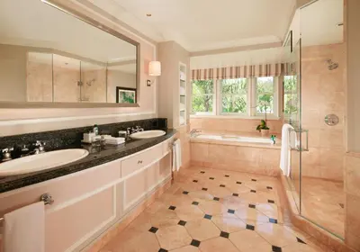 a bathroom with two sinks and a shower at The Beverly Hills Hotel - Dorchester Collection in Los Angeles