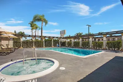 a swimming pool with a hot tub in a courtyard at Stanford Inn & Suites Anaheim in Anaheim