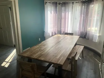 a wooden table and chairs in a room with windows at The Wilshire Metro in Los Angeles