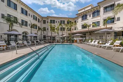 a pool at a hotel with chairs and umbrellas at Cambria Hotel Calabasas - Malibu in Calabasas