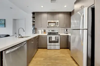 a kitchen with stainless steel appliances and wooden cabinets at Apart Hotel at Chinatown in Los Angeles
