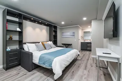 a bedroom with a large bed and a desk at Omeo Suites in Alhambra