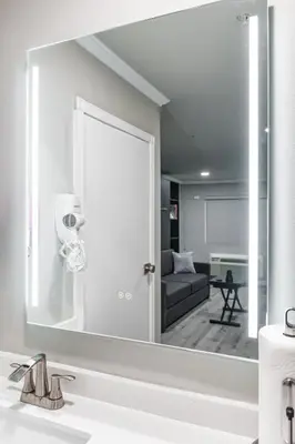 a mirror over a sink in a bathroom at Omeo Suites in Alhambra