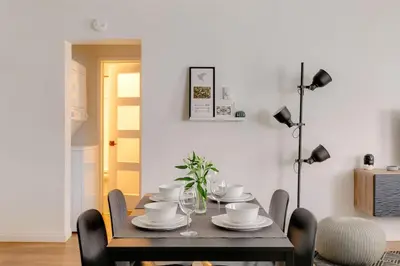 a dining room with a table with plates and cups at Sophisticated Long Beach Suite with Patio Dining and Parking NRP21-00185 in Long Beach