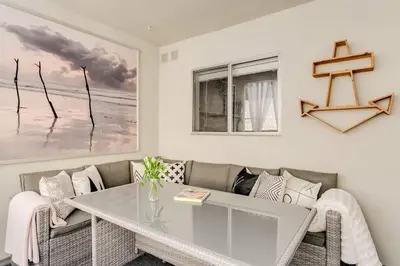 a living room with a glass table and a couch at Sophisticated Long Beach Suite with Patio Dining and Parking NRP21-00185 in Long Beach