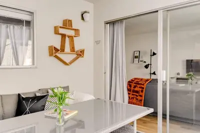 a white living room with a table and a bed at Sophisticated Long Beach Suite with Patio Dining and Parking NRP21-00185 in Long Beach