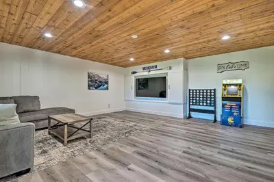 a living room with a couch and a tv at Airy Alpine Getaway with Lake Arrowhead Views! in Lake Arrowhead