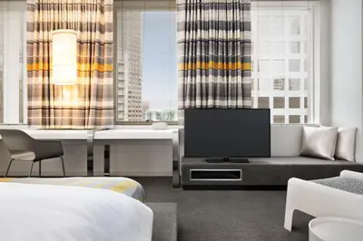 a hotel room with a tv and a couch and a bed at The Delphi Downtown LA in Los Angeles