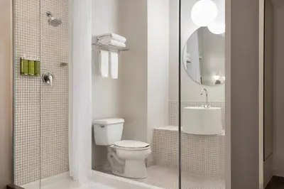 a bathroom with a toilet and a shower and a sink at The Delphi Downtown LA in Los Angeles