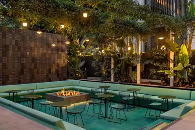a bar with tables and chairs and a fire pit at The Delphi Downtown LA in Los Angeles