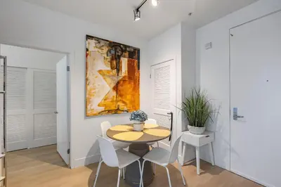 a dining room with a table and chairs and a painting at 1 Luxury Apartment in Los Angeles