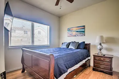 a bedroom with a bed with a blue comforter and a window at 5 Mi to Universal Studios Family Gem with Hot Tub! in Burbank