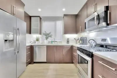 a kitchen with stainless steel appliances and wooden cabinets at 10 Cozy apartment heart of Santa Monica in Los Angeles